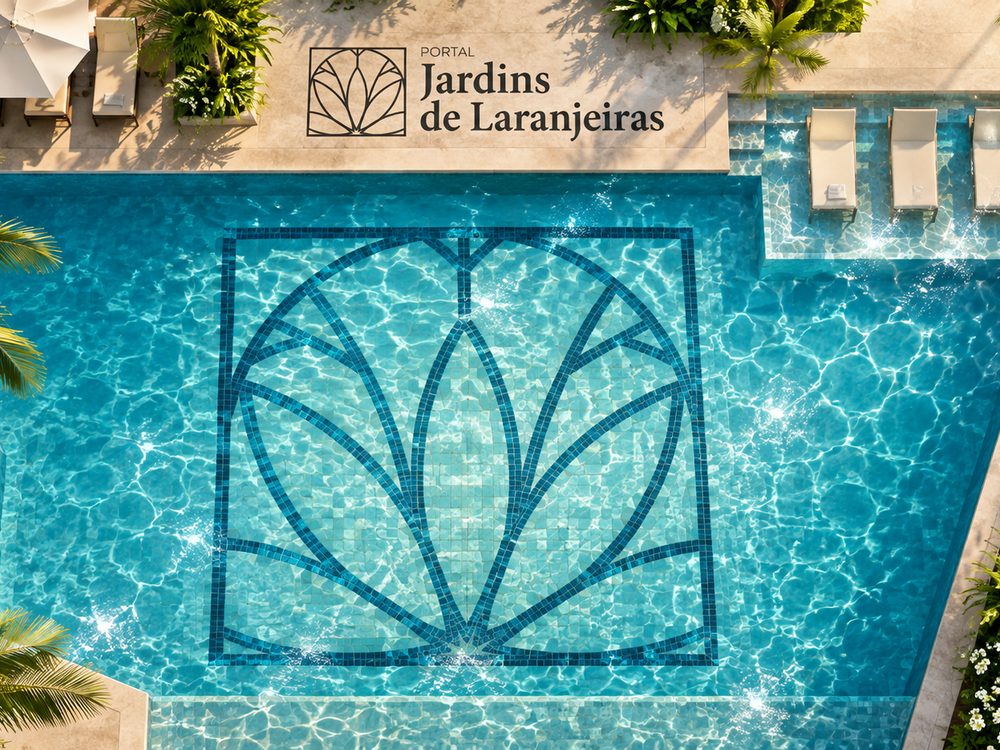 Piscina do condomínio vista de cima, com o símbolo do Portal Jardins no fundo e espreguiçadeiras ao redor